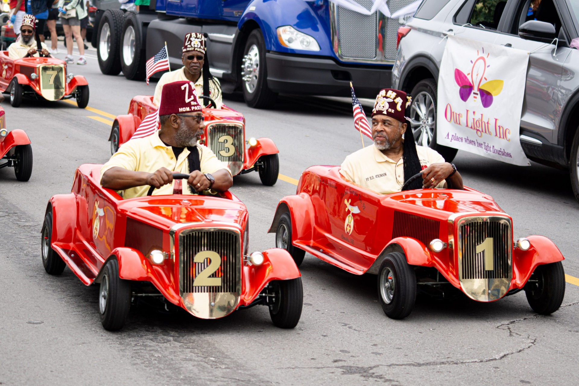 Shriners driving mini red cars in the parade